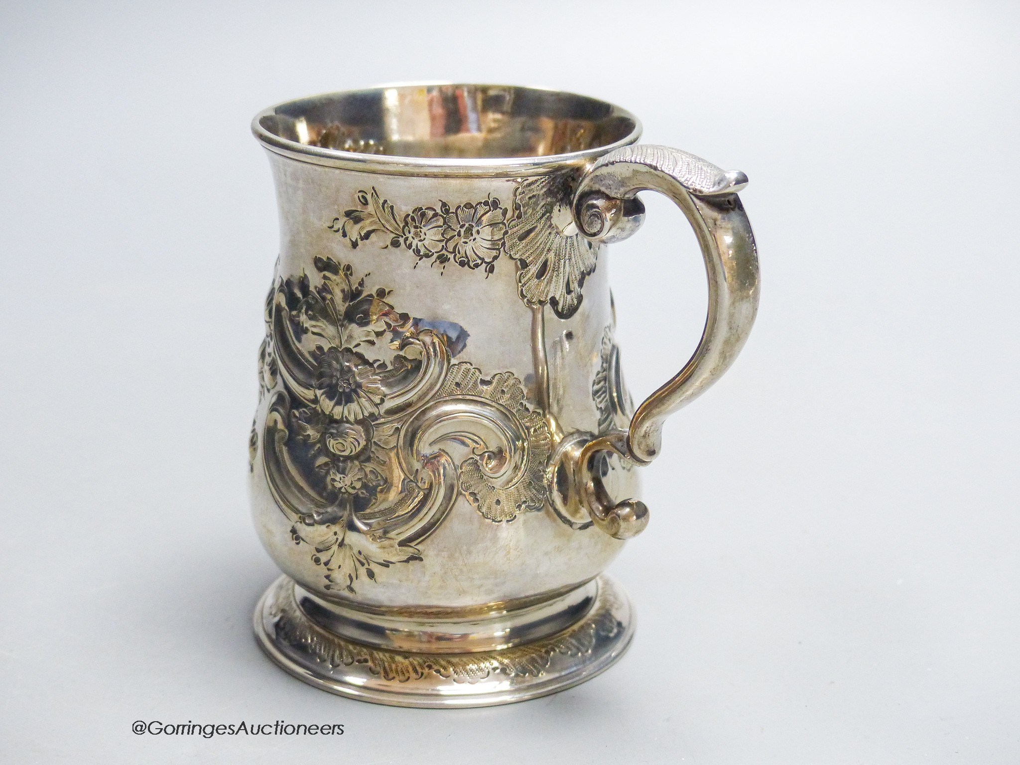 A George II provincial silver baluster mug, with later embossed decoration, James Kirkup, Newcastle, 1751, 10cm, 5.5oz.